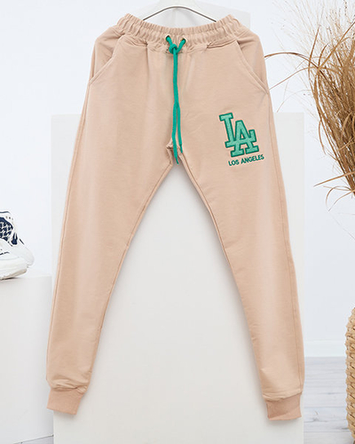 Женские бежевые спортивные штаны с цветной нашивкой - Одежда